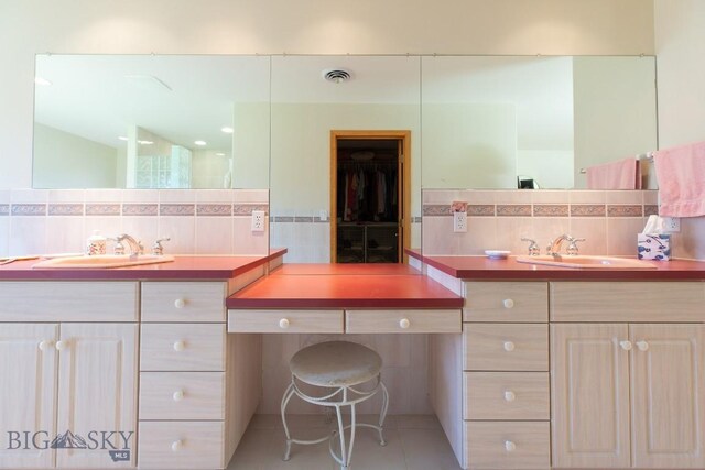 full bath with tile walls, decorative backsplash, a sink, and tile patterned flooring