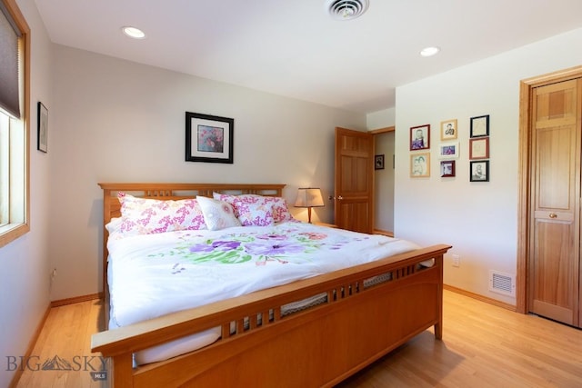 bedroom with light wood-style floors, baseboards, and visible vents