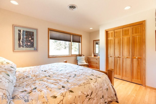 bedroom featuring recessed lighting, visible vents, a closet, and light wood-style floors