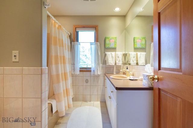 full bathroom with vanity, curtained shower, visible vents, and tile walls