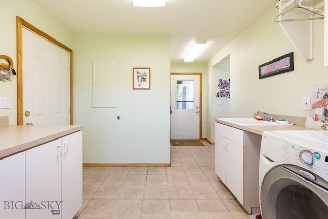 laundry room with cabinet space, light tile patterned flooring, a sink, baseboards, and washer / dryer