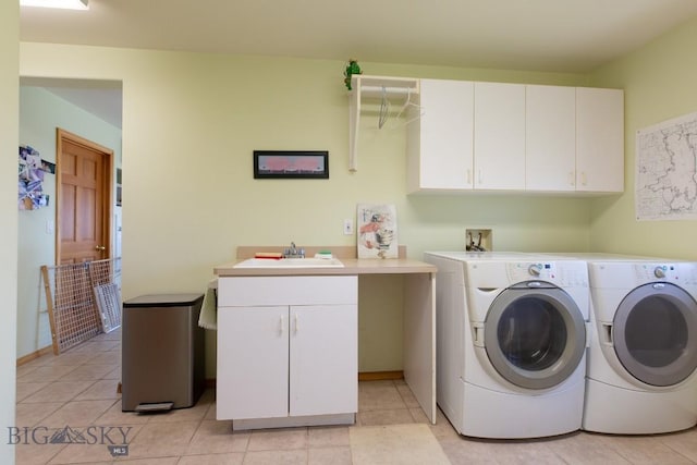 washroom with a sink, light tile patterned flooring, cabinet space, and washer and clothes dryer
