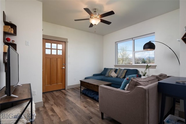 living area featuring a ceiling fan, baseboards, a wealth of natural light, and wood finished floors