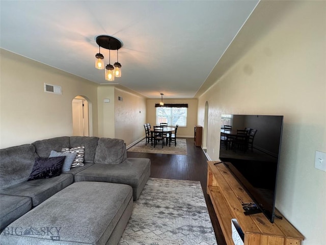216 W 2nd Ave, Big Timber, MT 59011 - living area with arched walkways, baseboards, wood finished floors, and visible vents