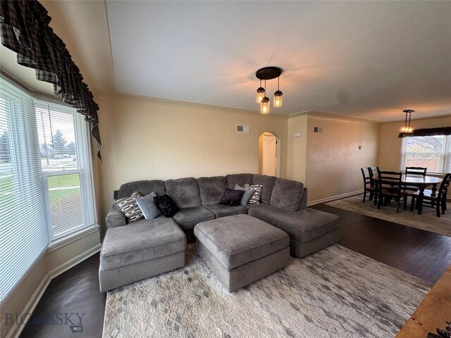 216 W 2nd Ave, Big Timber, MT 59011 - living room with arched walkways, baseboards, visible vents, and wood finished floors