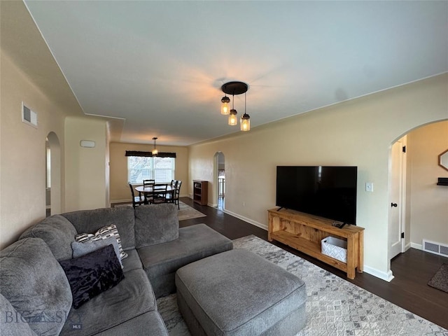216 W 2nd Ave, Big Timber, MT 59011 - living room with arched walkways, dark wood-style flooring, and visible vents