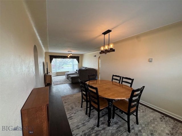 216 W 2nd Ave, Big Timber, MT 59011 - dining space featuring baseboards, arched walkways, and wood finished floors