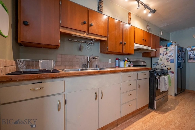 124 S M St, Livingston, MT 59047 - kitchen with a sink, light wood finished floors, range with gas stovetop, under cabinet range hood, and stainless steel refrigerator with ice dispenser