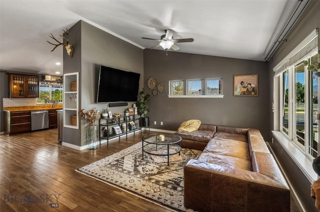 living area featuring a ceiling fan, baseboards, vaulted ceiling, and dark wood-type flooring