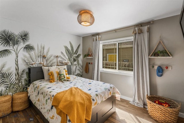 bedroom featuring baseboards and wood finished floors
