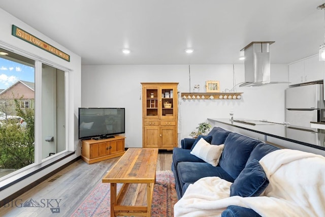 living room featuring recessed lighting, visible vents, and light wood-style flooring