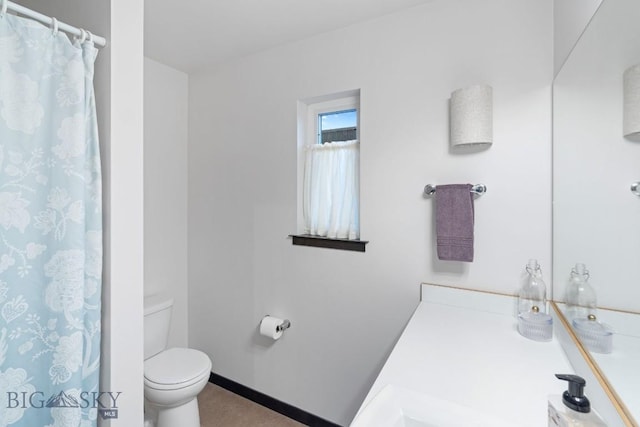 bathroom with a shower with curtain, baseboards, and toilet