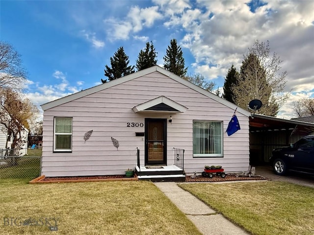 bungalow-style house featuring fence, a front lawn, and an attached carport
