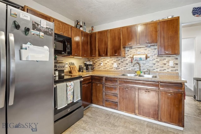 2300 S Dr, Butte, MT 59701 - kitchen featuring a sink, stainless steel appliances, brown cabinets, light countertops, and decorative backsplash