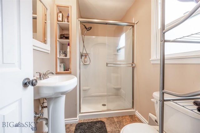 2300 S Dr, Butte, MT 59701 - bathroom featuring toilet, baseboards, a stall shower, and built in shelves