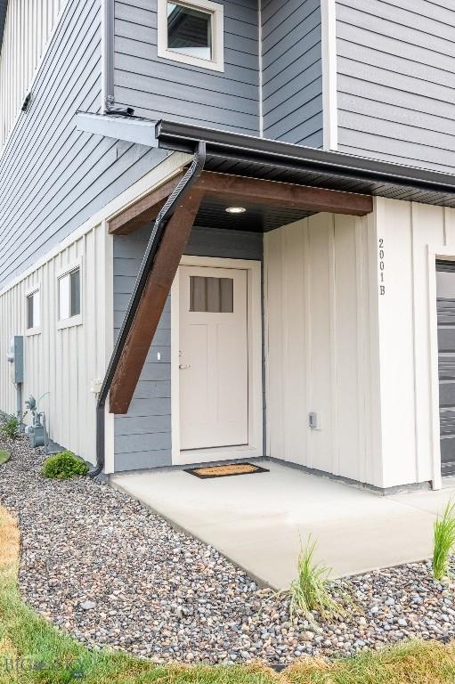 doorway to property featuring a garage and board and batten siding