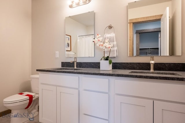 bathroom with double vanity, toilet, tile patterned floors, and a sink