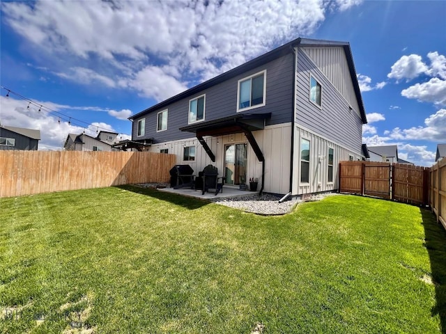 back of house with a lawn, a patio, and board and batten siding