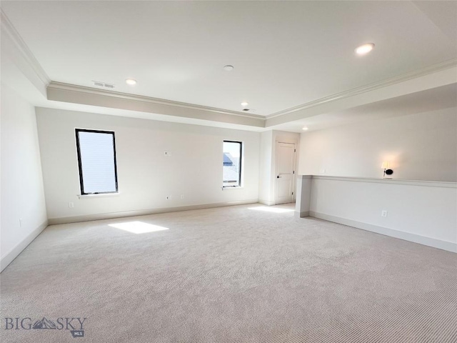 empty room featuring crown molding, recessed lighting, light carpet, and a raised ceiling