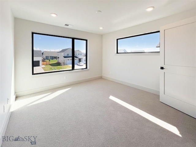 unfurnished room featuring recessed lighting, visible vents, and plenty of natural light