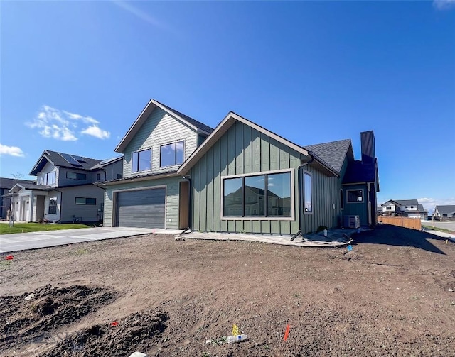 51 W Granite Peak, Bozeman, MT 59718 - view of front of property with driveway, board and batten siding, an attached garage, and central air condition unit