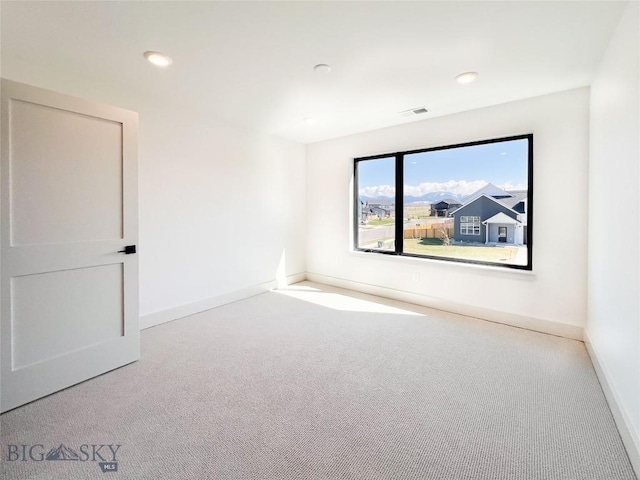 empty room featuring baseboards, carpet flooring, recessed lighting, and visible vents