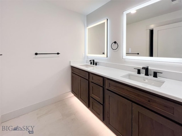 bathroom featuring a sink, baseboards, double vanity, and marble finish floor