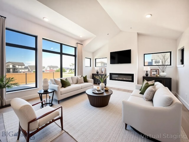 51 W Granite Peak, Bozeman, MT 59718 - living room with wood finished floors, vaulted ceiling, a glass covered fireplace, and recessed lighting