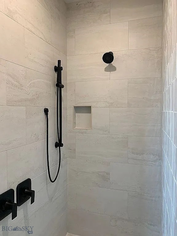 interior details featuring a tile shower