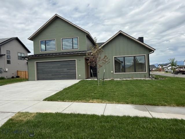 51 W Granite Peak, Bozeman, MT 59718 - view of front of home featuring board and batten siding, concrete driveway, an attached garage, a front lawn, and a chimney