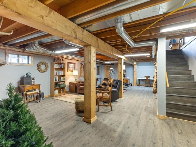 basement with baseboards, wood finished floors, and stairway