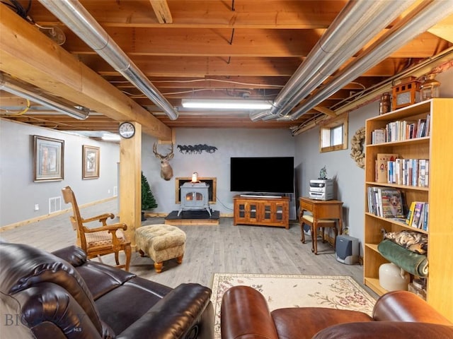 living room featuring a wood stove and wood finished floors
