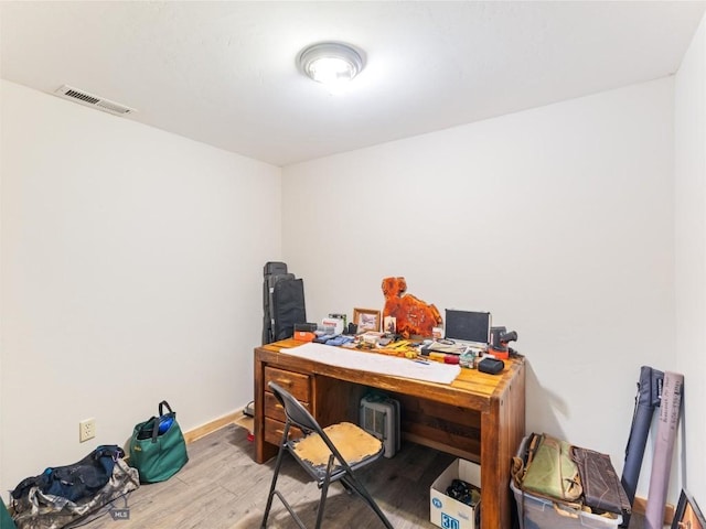 office featuring visible vents, baseboards, and wood finished floors