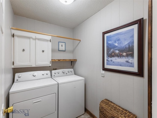 washroom with cabinet space, separate washer and dryer, and a textured ceiling