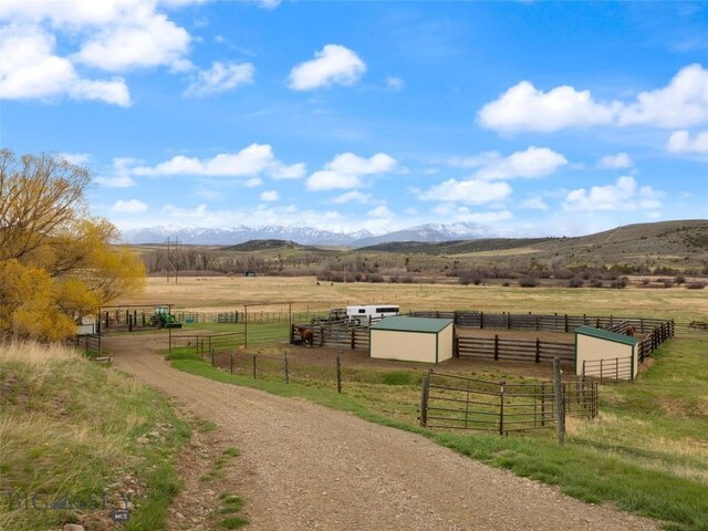 view of property's community featuring an exterior structure, a rural view, an outbuilding, and a mountain view