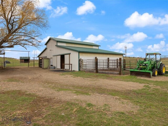 view of pole building with an exterior structure and fence