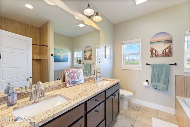 bathroom featuring toilet, a bathtub, baseboards, and a sink