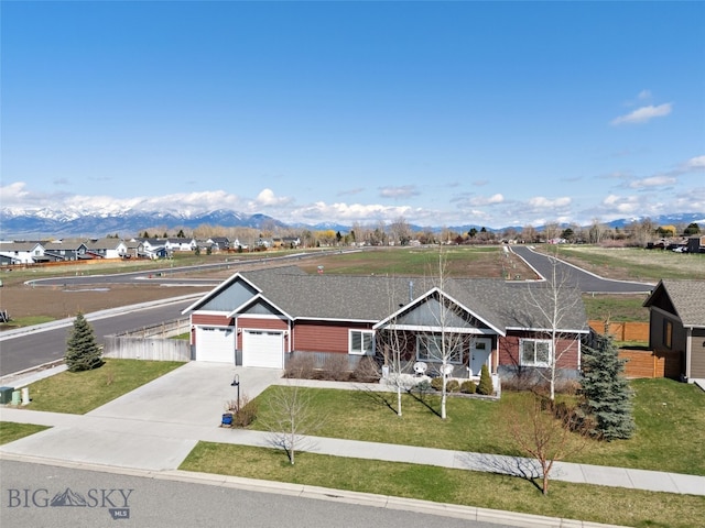 single story home featuring a garage, a mountain view, driveway, and a front yard