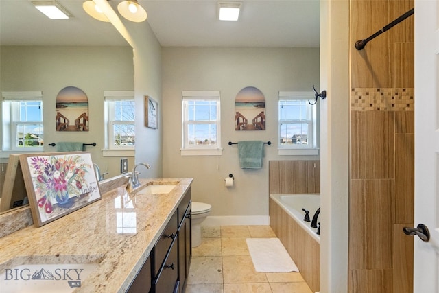 bathroom featuring a sink, double vanity, toilet, baseboards, and tiled tub