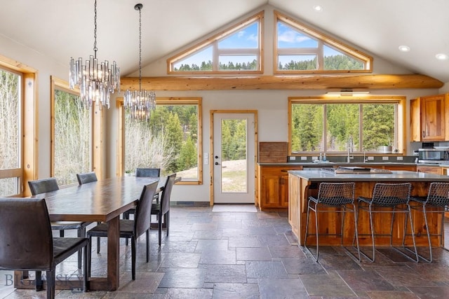 dining area featuring a healthy amount of sunlight, lofted ceiling, and stone tile flooring