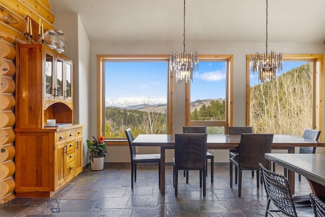 dining room with an inviting chandelier, stone tile floors, and a wealth of natural light
