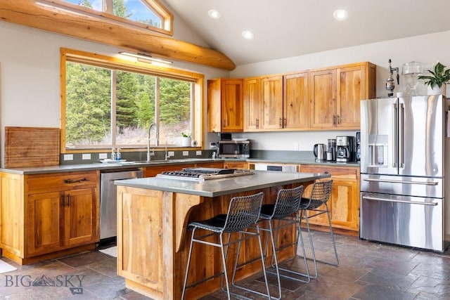 kitchen featuring appliances with stainless steel finishes, a center island, recessed lighting, and stone tile flooring