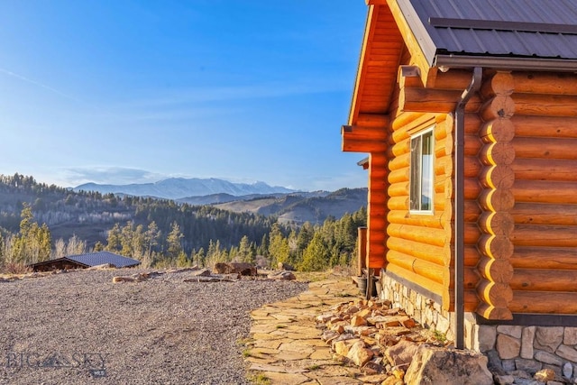 view of home's exterior featuring a mountain view and log siding