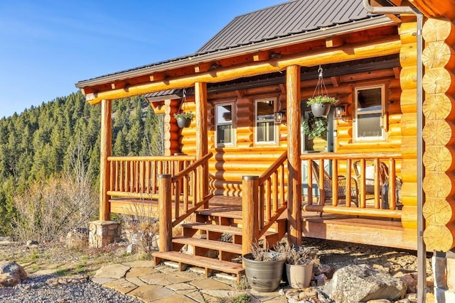 wooden deck featuring a porch and a wooded view