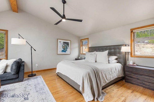 bedroom featuring vaulted ceiling with beams, a ceiling fan, light wood-style floors, and baseboards