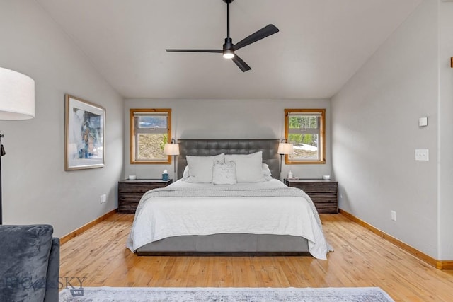bedroom with wood finished floors, a ceiling fan, baseboards, and lofted ceiling
