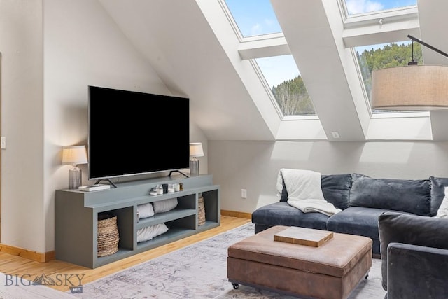 living room with baseboards, lofted ceiling with skylight, and wood finished floors