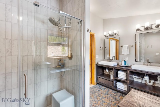 full bath with a sink, a stall shower, and double vanity