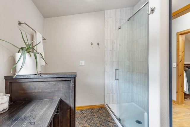 full bathroom featuring baseboards, a shower stall, and vanity