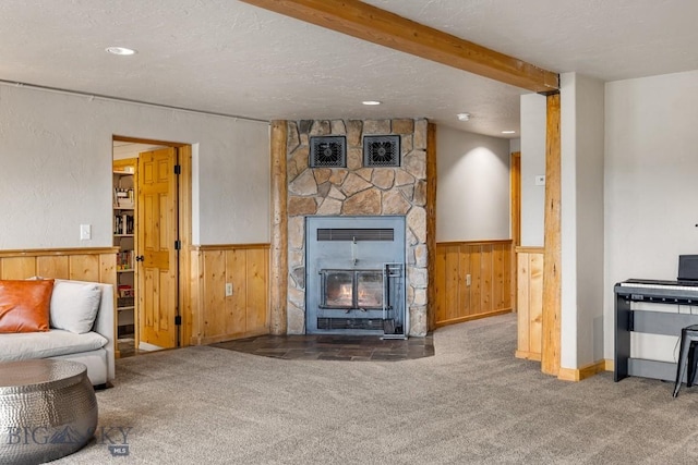 carpeted living area featuring wooden walls, heating unit, and wainscoting